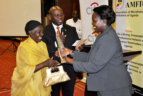 Twinomugisha receiving the Gold award from Hon. Minister of Microfinance